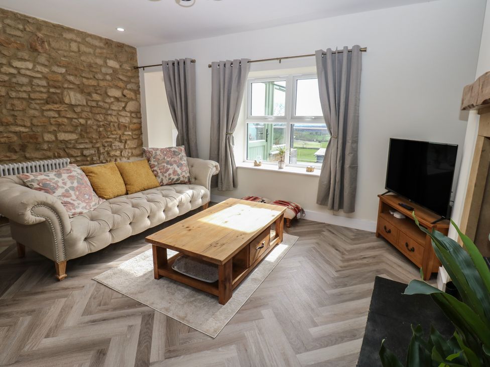 A living room with a sofa and coffee table at 2 Low Road