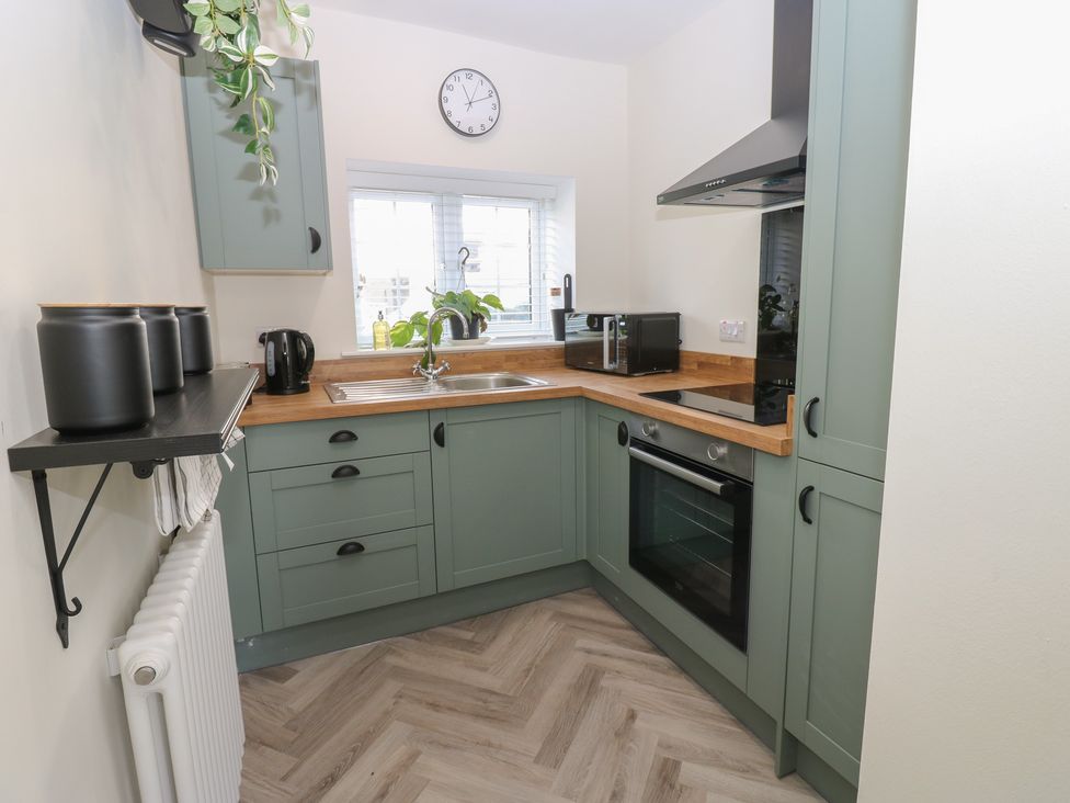 A kitchen with a sink and appliances at 2 Low Road