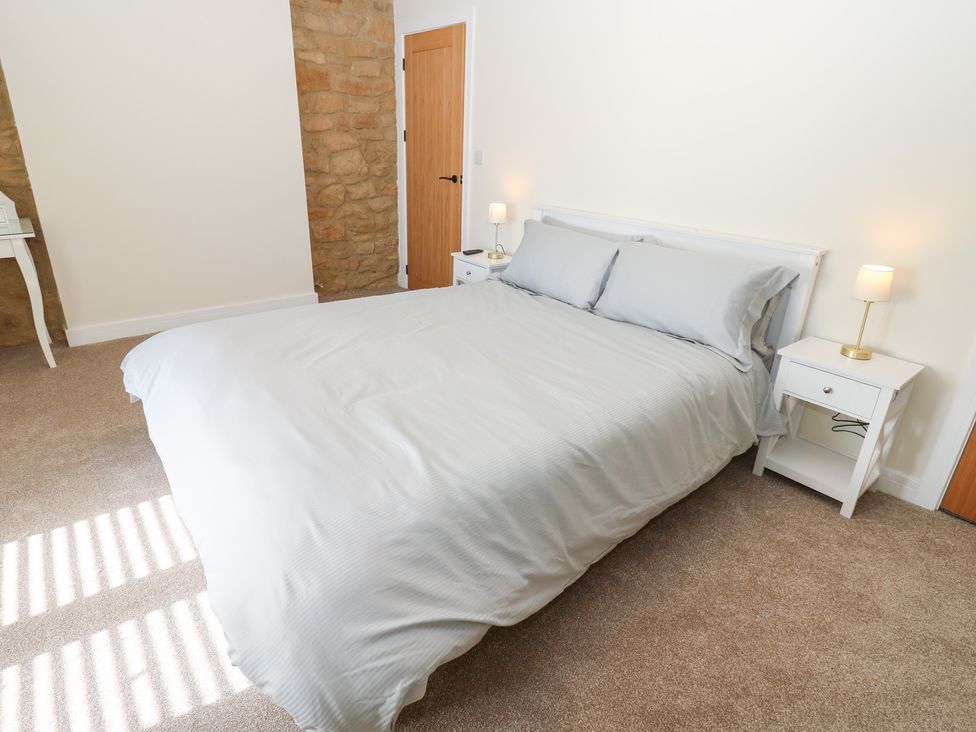 A bedroom with a bed and nightstands at 2 Low Road