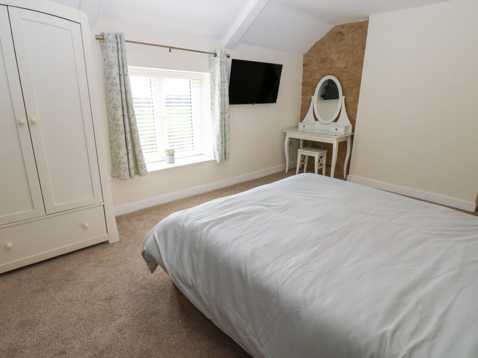 A bedroom with a bed, wardrobe, and dressing table at 2 Low Road 