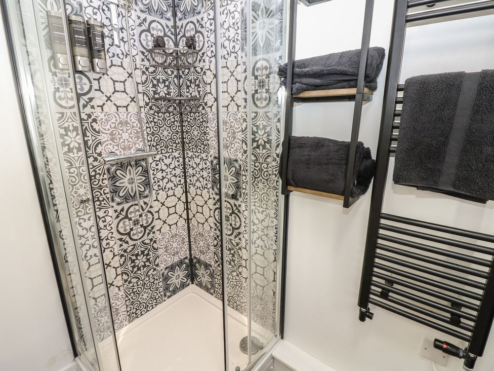 A shower with soap dispensers and towels at 2 Low Road