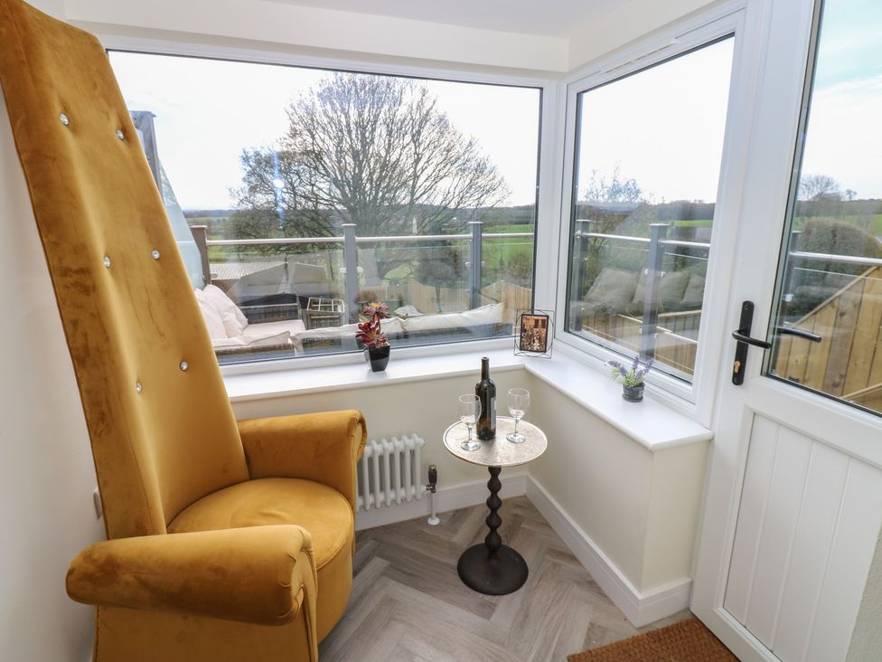 A snug with an armchair and table in a corner at 2 Low Road