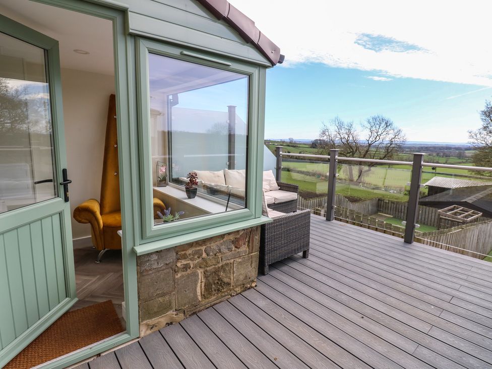A conservatory with a seating area and outdoor view at 2 Low Road