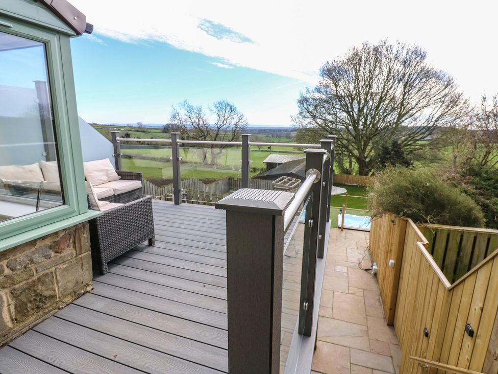 A decking area with furniture and a view at 2 Low Road