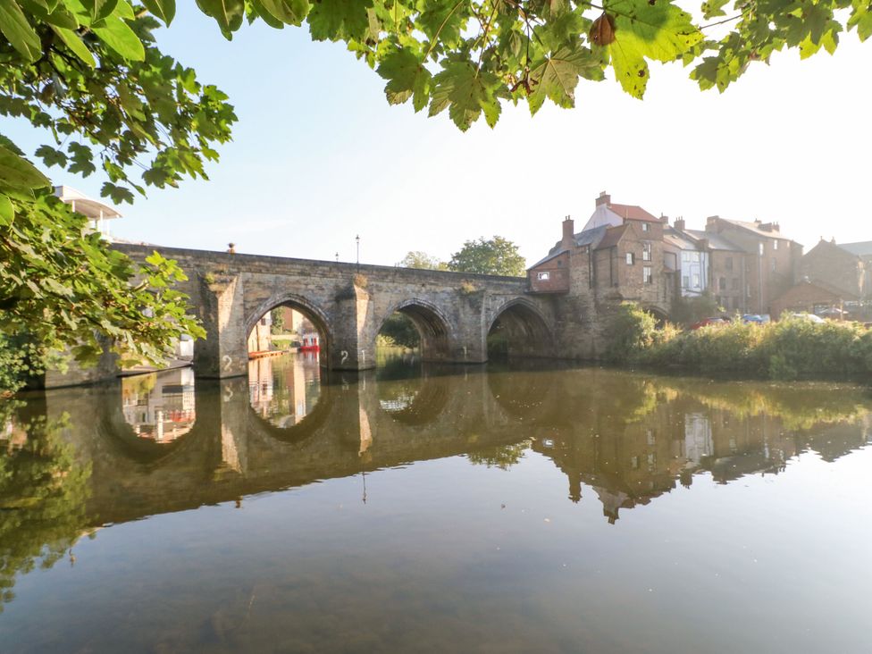 A bridge over water with buildings in the background at 2 Low Road 