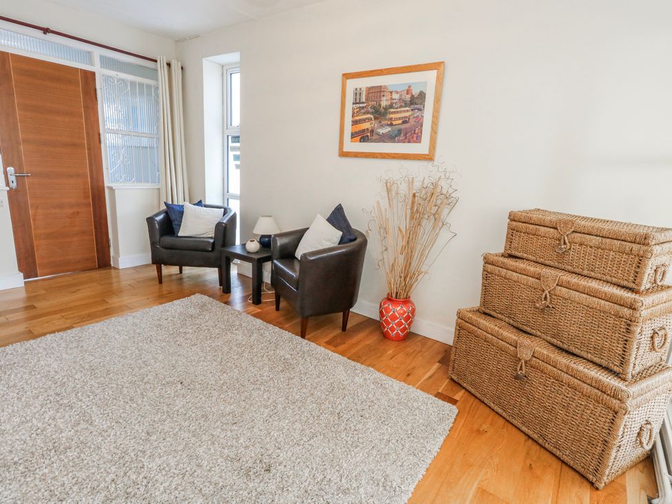 A living room with armchairs and storage boxes at Flat 17 Golden Gates in Poole