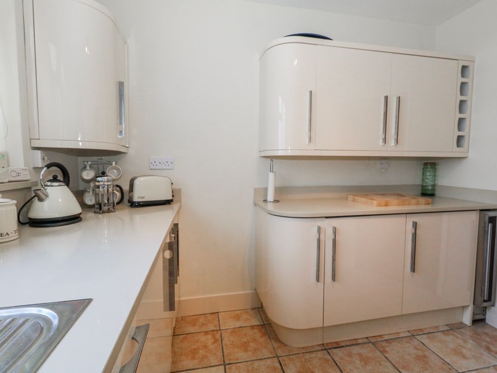 A kitchen with a kettle, toaster, and cutting board at Flat 17 Golden Gates in Poole