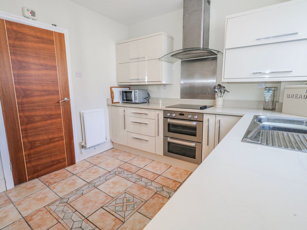 A kitchen with cabinets and a microwave at Flat 17 Golden Gates in Poole