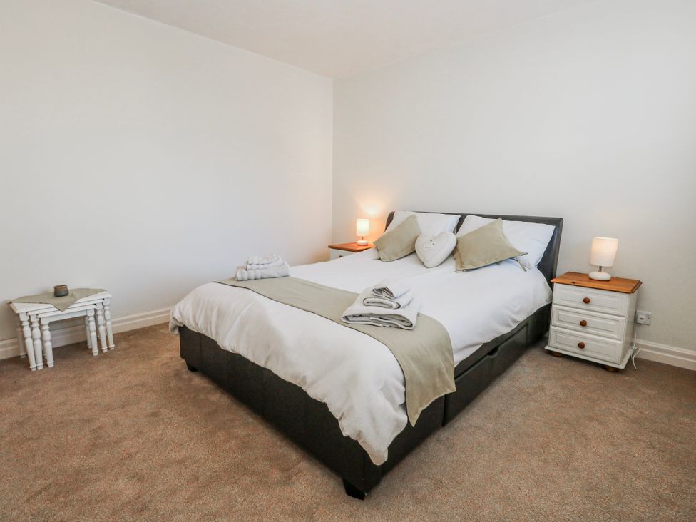 A bedroom with a bed and bedside tables at Flat 17 Golden Gates in Poole