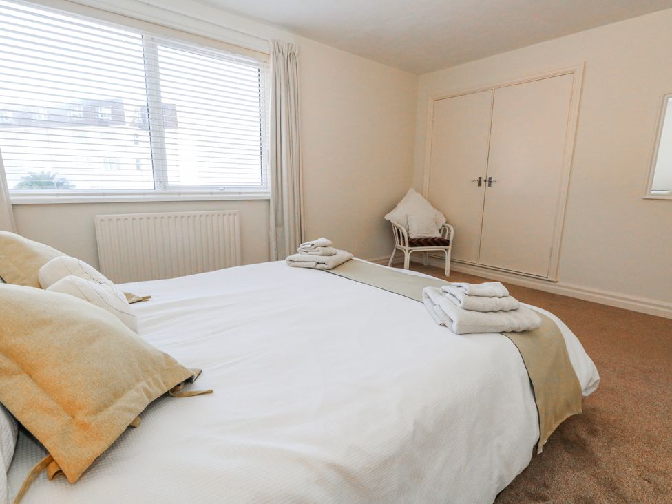 A bedroom with a bed and a chair at Flat 17 Golden Gates in Poole