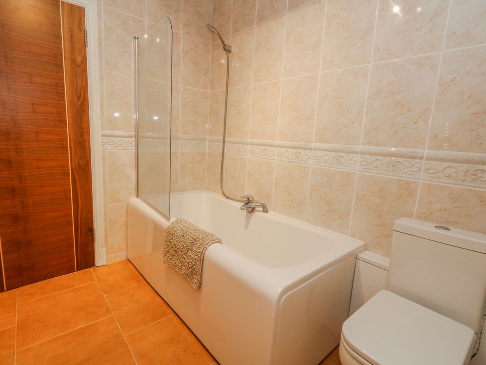 A bathroom with a bath tub and toilet at Flat 17 Golden Gates in Poole