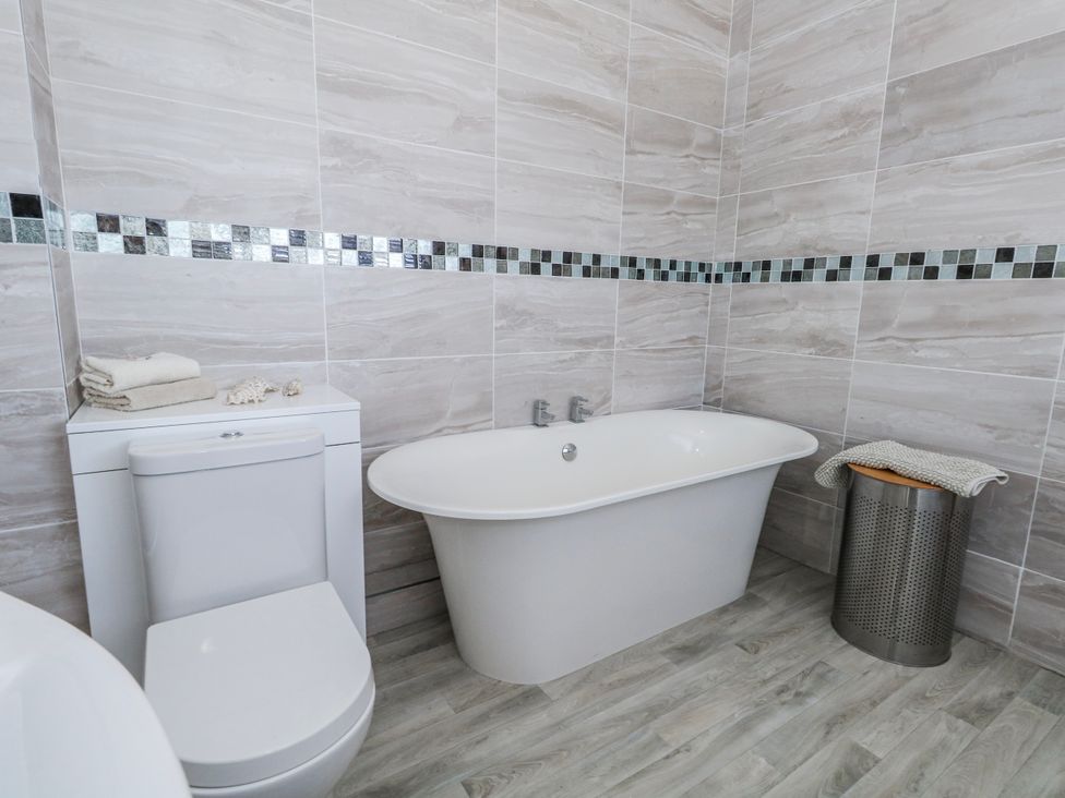 A bathroom with a toilet and a bathtub at Flat 17 Golden Gates in Poole