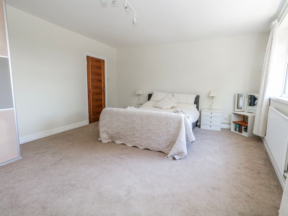 A bedroom with a bed and nightstands at Flat 17 Golden Gates in Poole