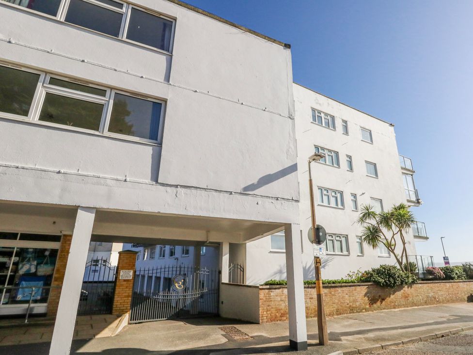 An apartment building with a gate and parking area at Flat 17 Golden Gates in Poole
