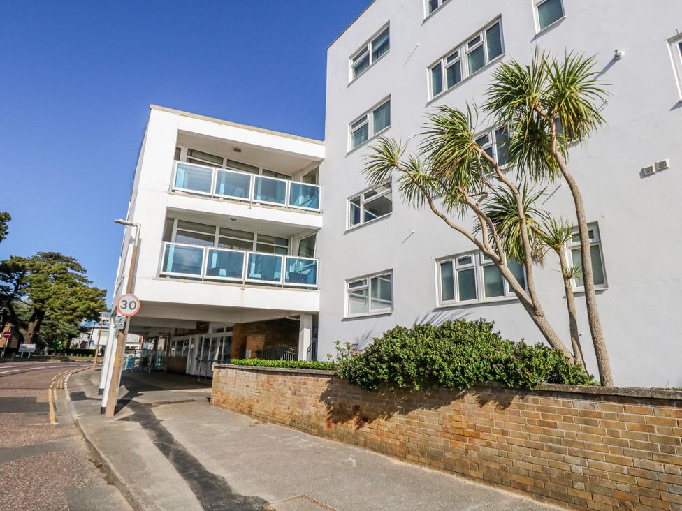 A building with balconies and palm trees at Flat 17 Golden Gates in Poole