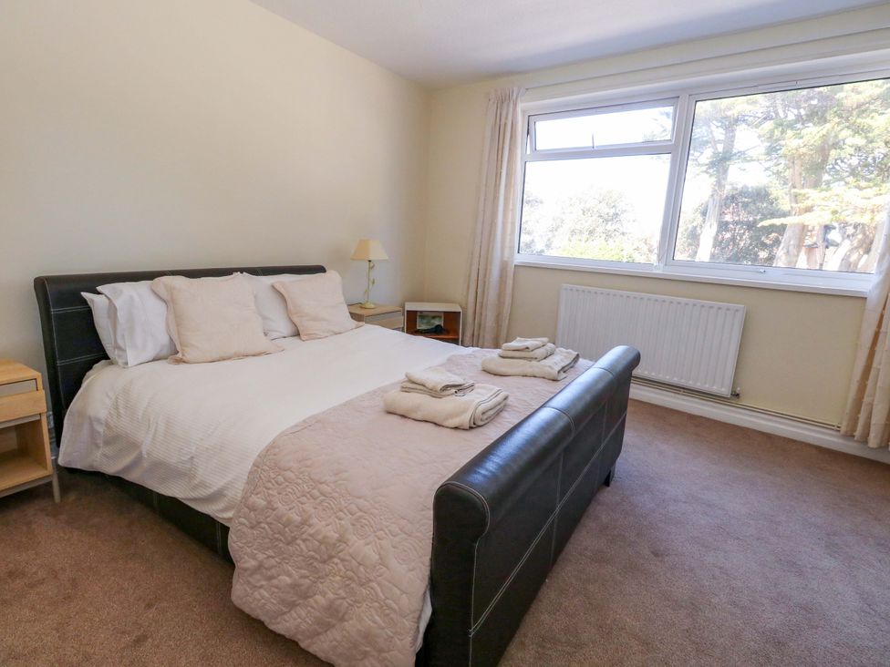 A bedroom with a bed and nightstand at Flat 17 Golden Gates Sandbanks