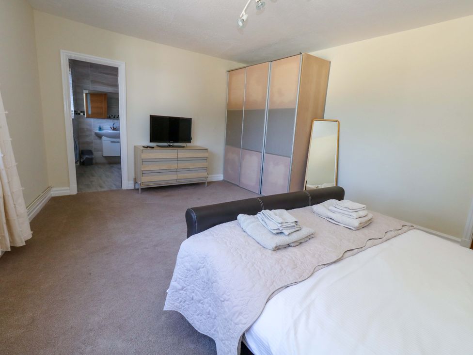 A bedroom with a bed and television at Flat 17 Golden Gates Sandbanks