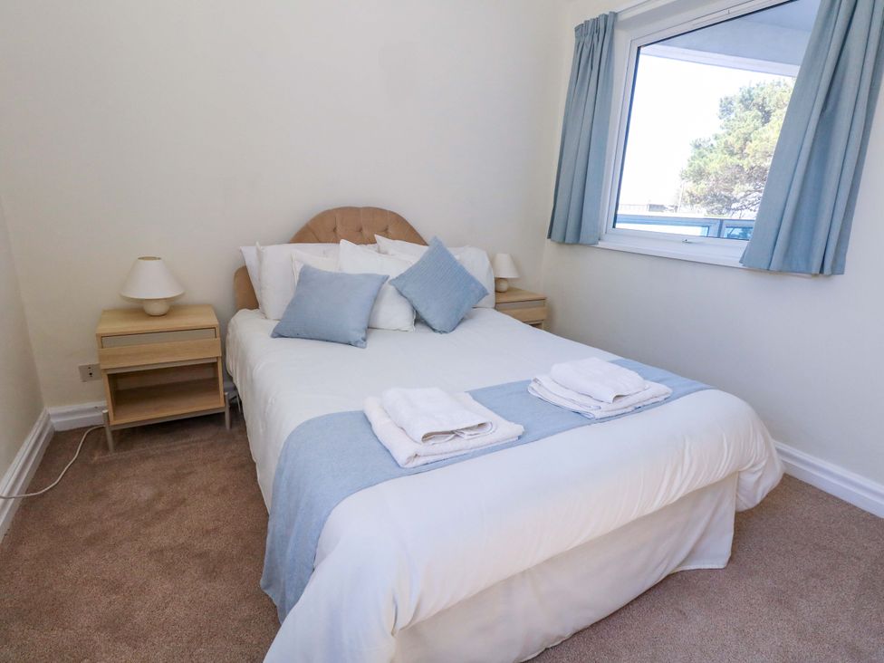 A bedroom with a bed and bedside tables at Flat 17 Golden Gates in Sandbanks