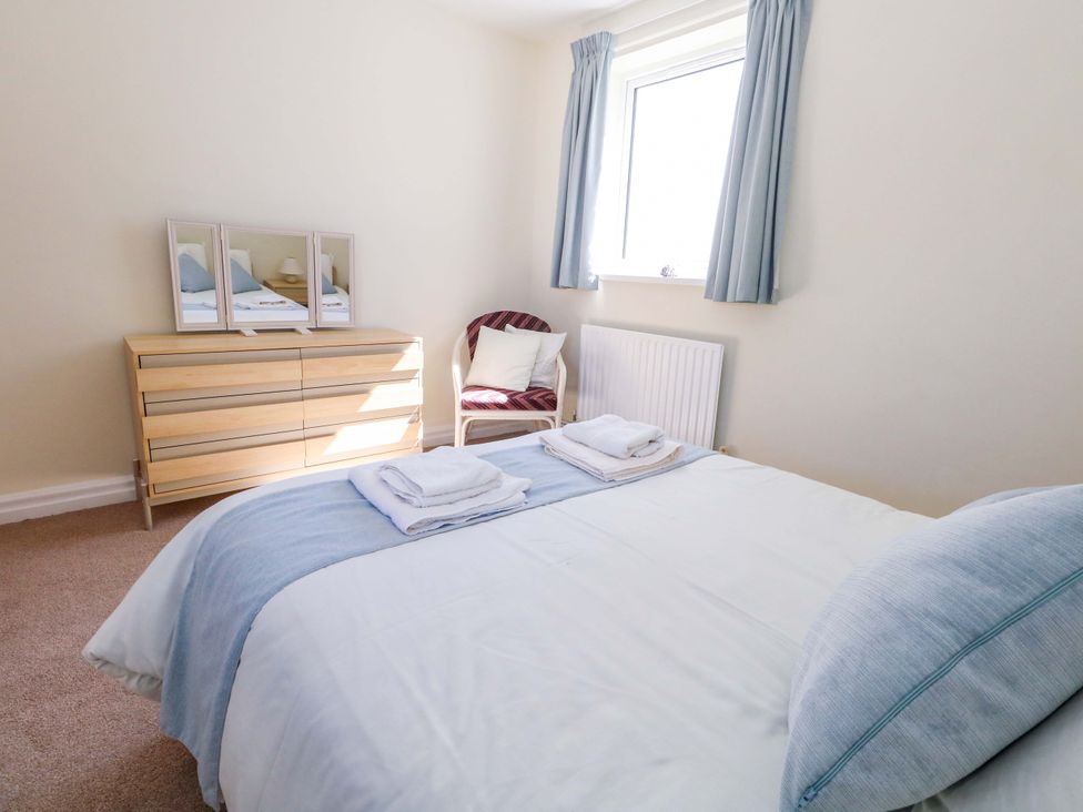 A bedroom with a bed and dresser at Flat 17 Golden Gates in Sandbanks