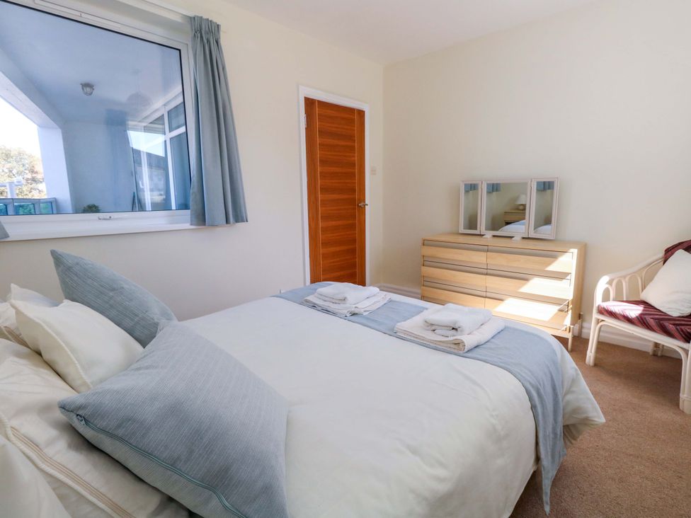 A bedroom with a bed and a dressing table at Flat 17 Golden Gates Sandbanks