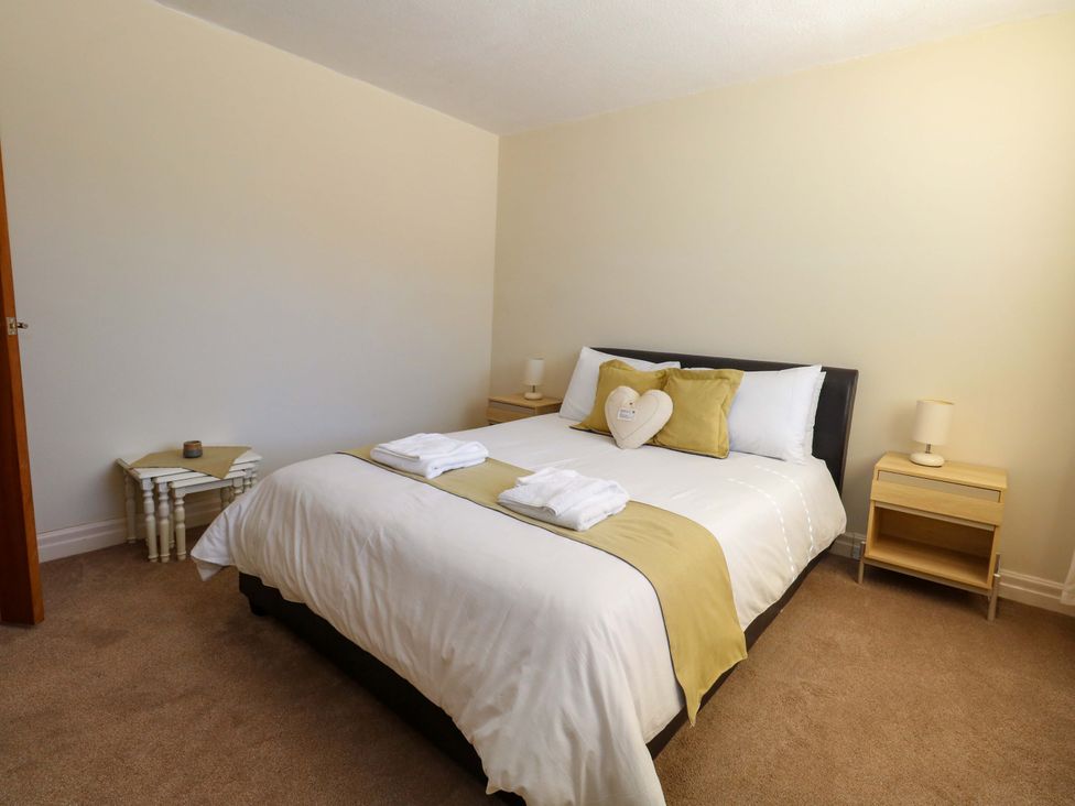 A bedroom with a bed and bedside tables at Flat 17 Golden Gates Sandbanks