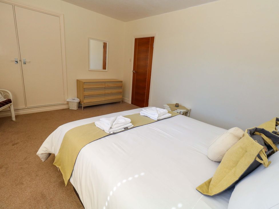 A bedroom with a bed and dresser at Flat 17 Golden Gates Sandbanks