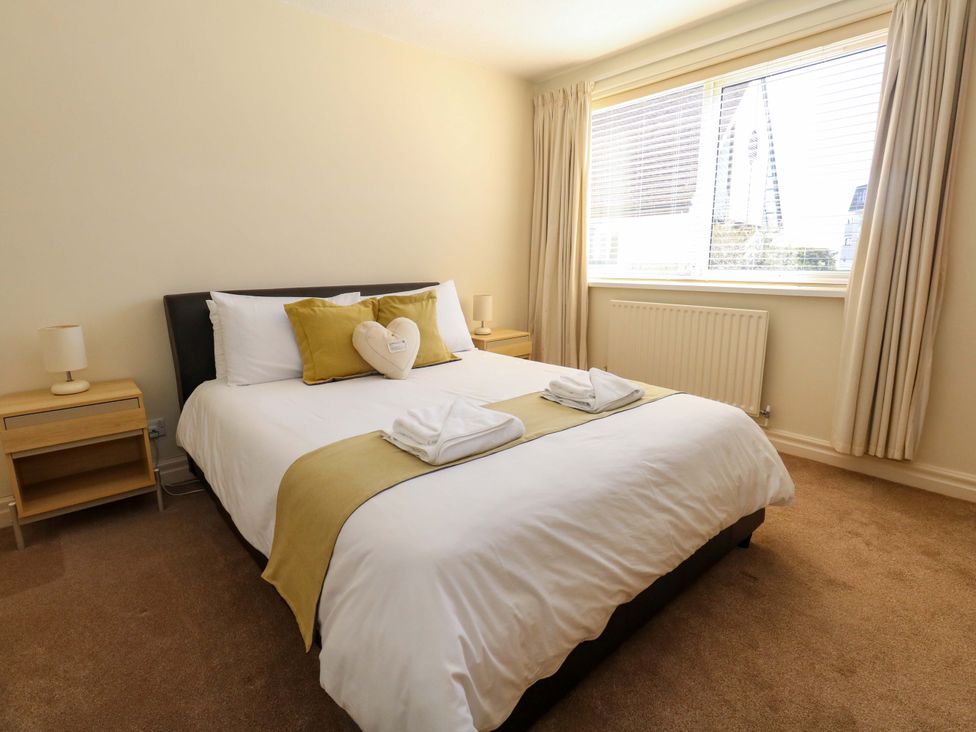 A bedroom with a bed and nightstand at Flat 17 Golden Gates in Sandbanks