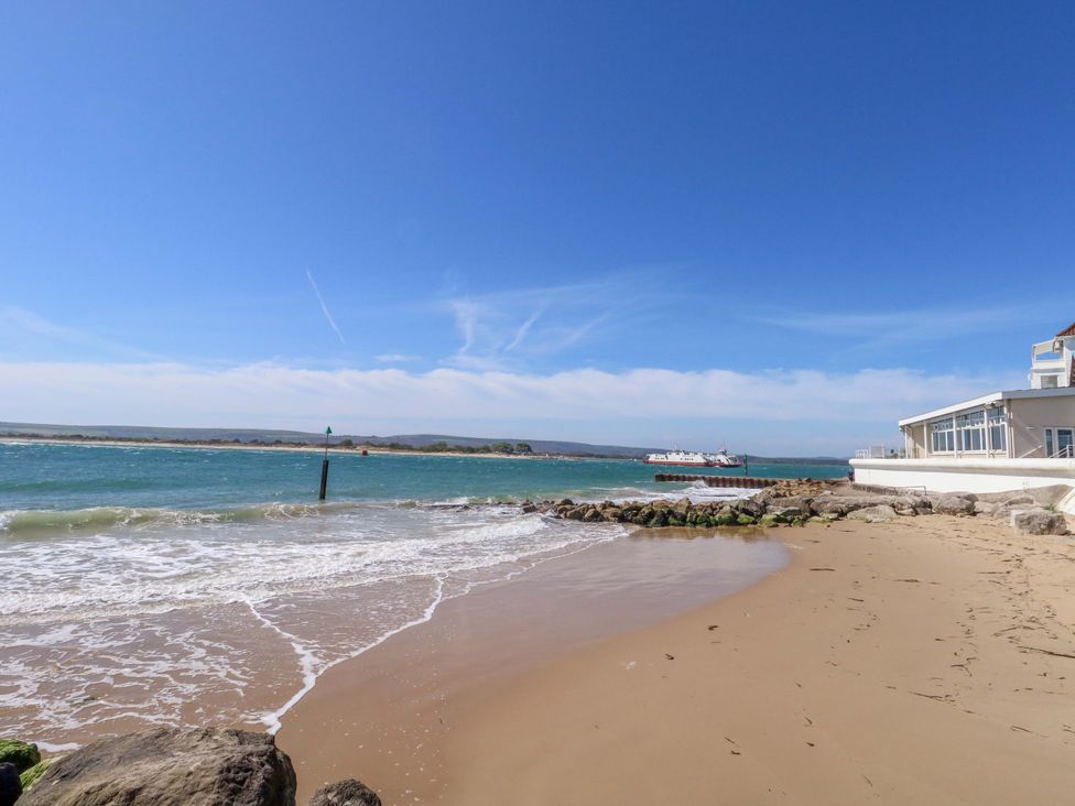 A beach view with water and a ferry at Flat 17 Golden Gates Sandbanks