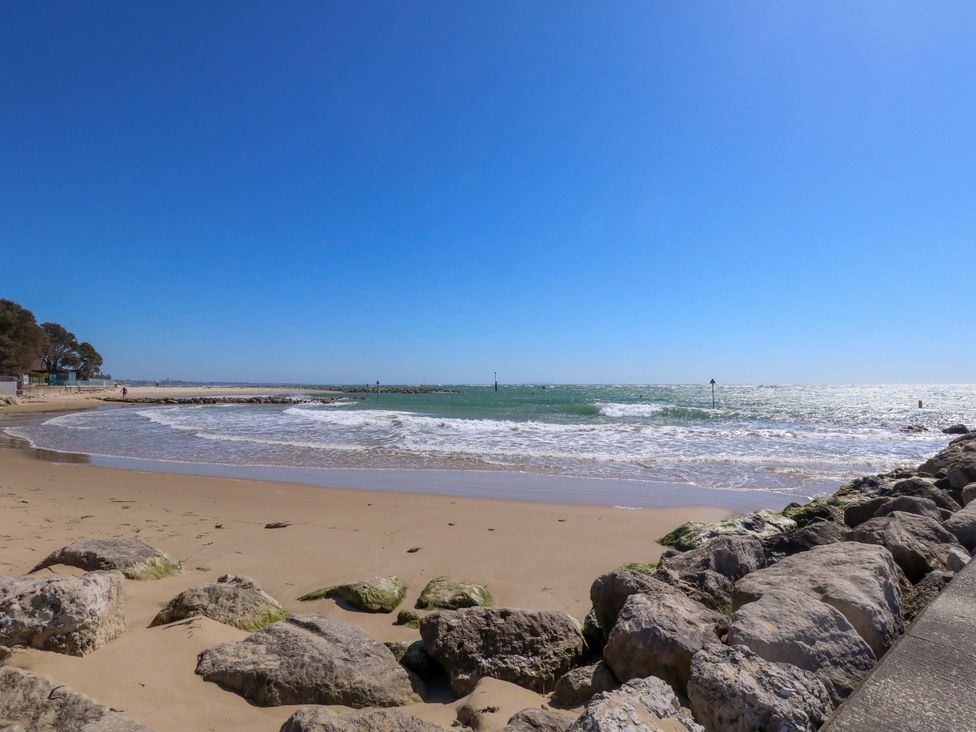 A beach with waves and rocks at Flat 17 Golden Gates Sandbanks