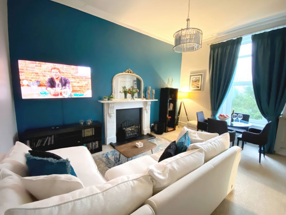 A living room with a sofa and television at 2A Redcliffe in Torquay