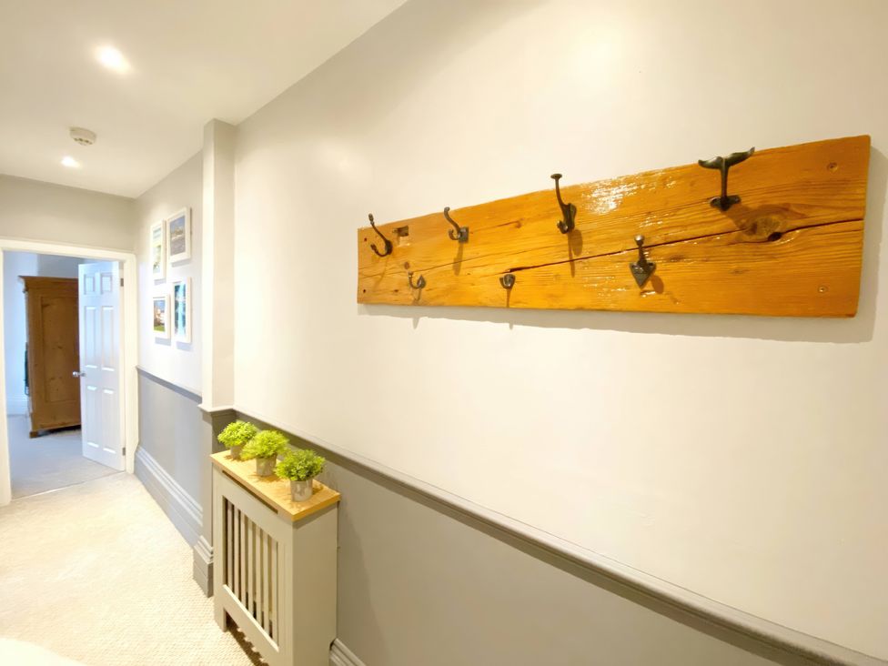A hallway with wall hooks and a wooden panel at 2A Redcliffe, Torquay