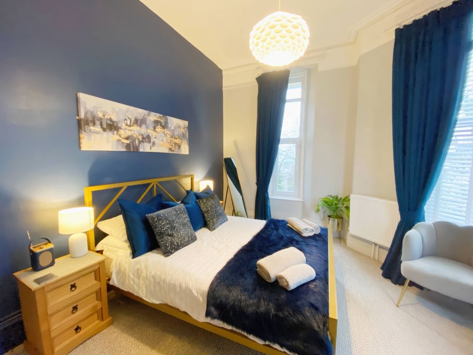 A bedroom with a bed and side table at 2A Redcliffe in Torquay