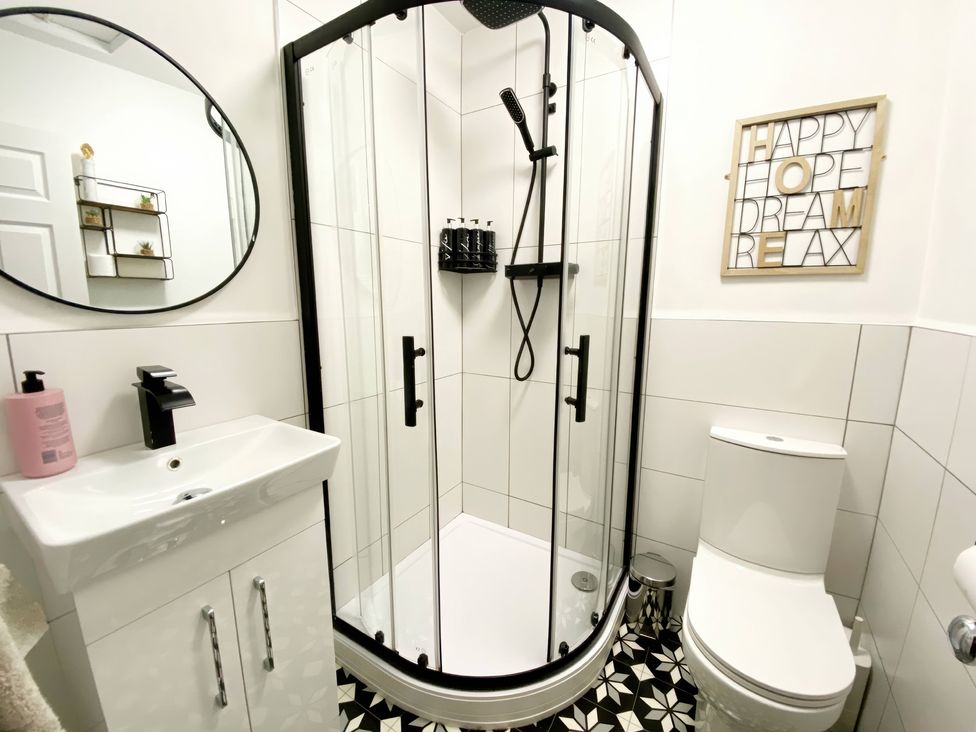 A bathroom with a shower enclosure, sink, and toilet at 2A Redcliffe in Torquay