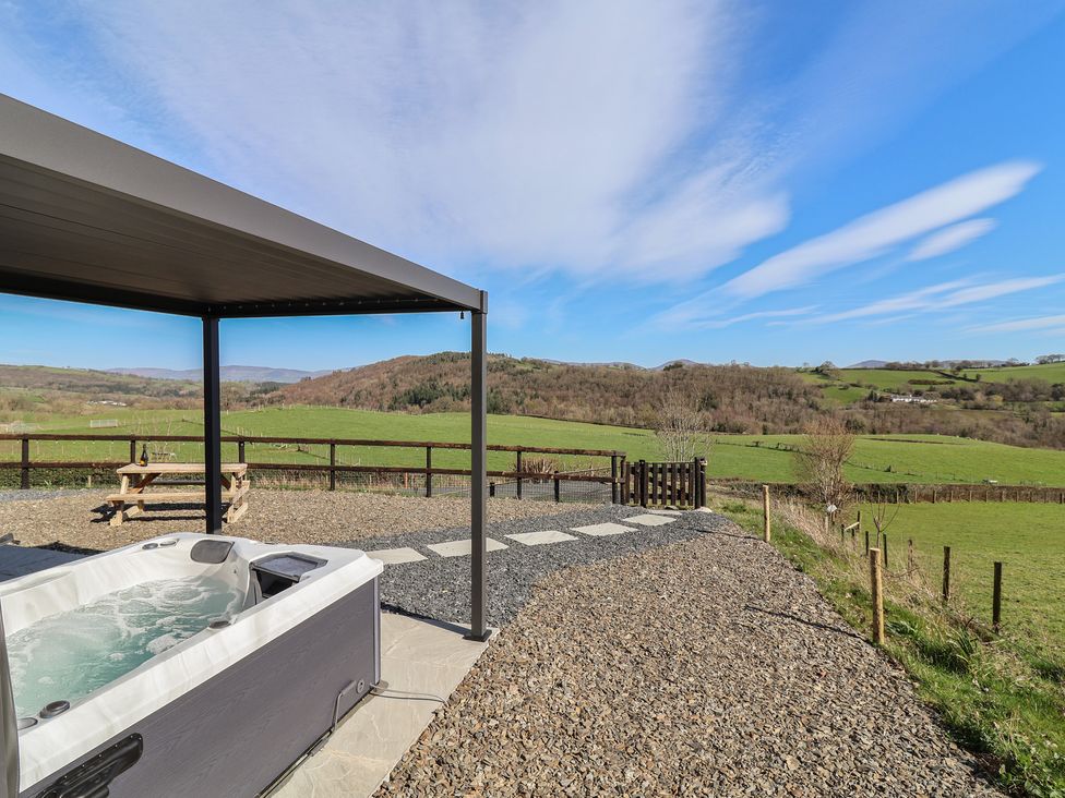 An outdoor area with a hot tub and a picnic table at Cennin Pedr Ruthin