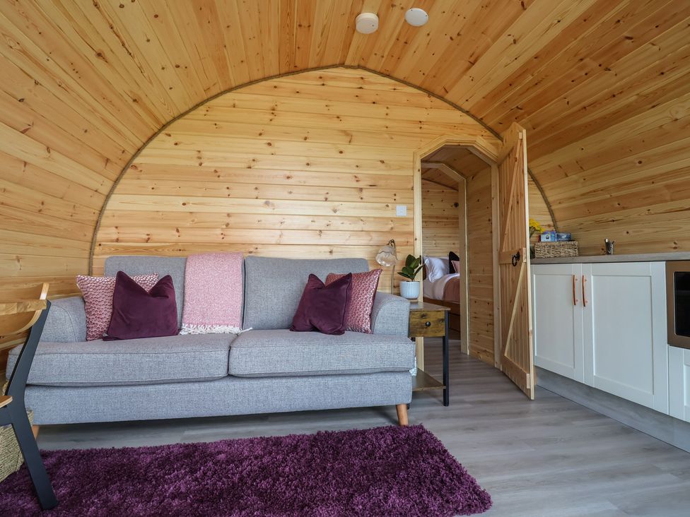A living room with a sofa and a rug at Cennin Pedr in Ruthin