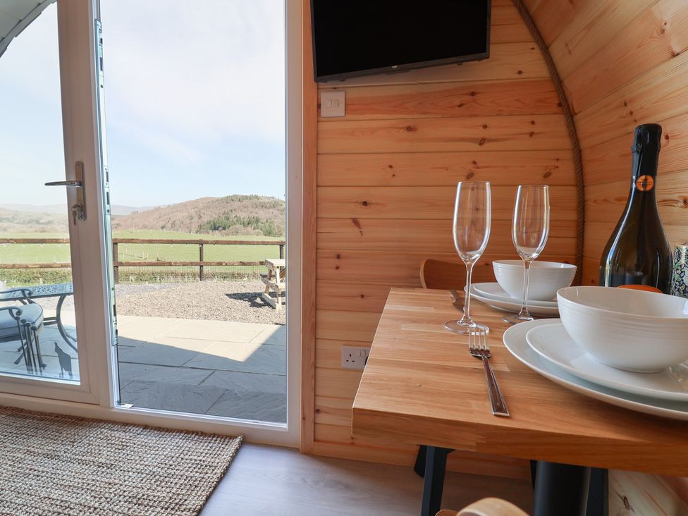 A dining area with a table set for a meal at Cennin Pedr in Ruthin