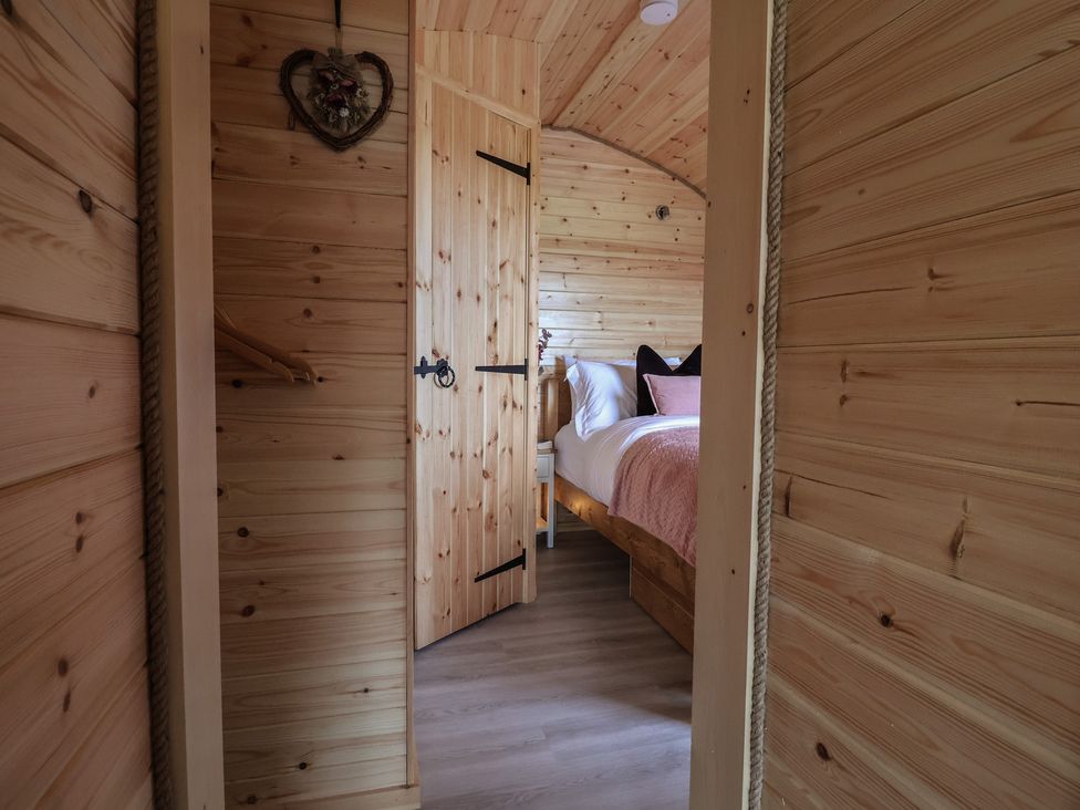 A bedroom with wooden elements and a bed at Cennin Pedr in Ruthin