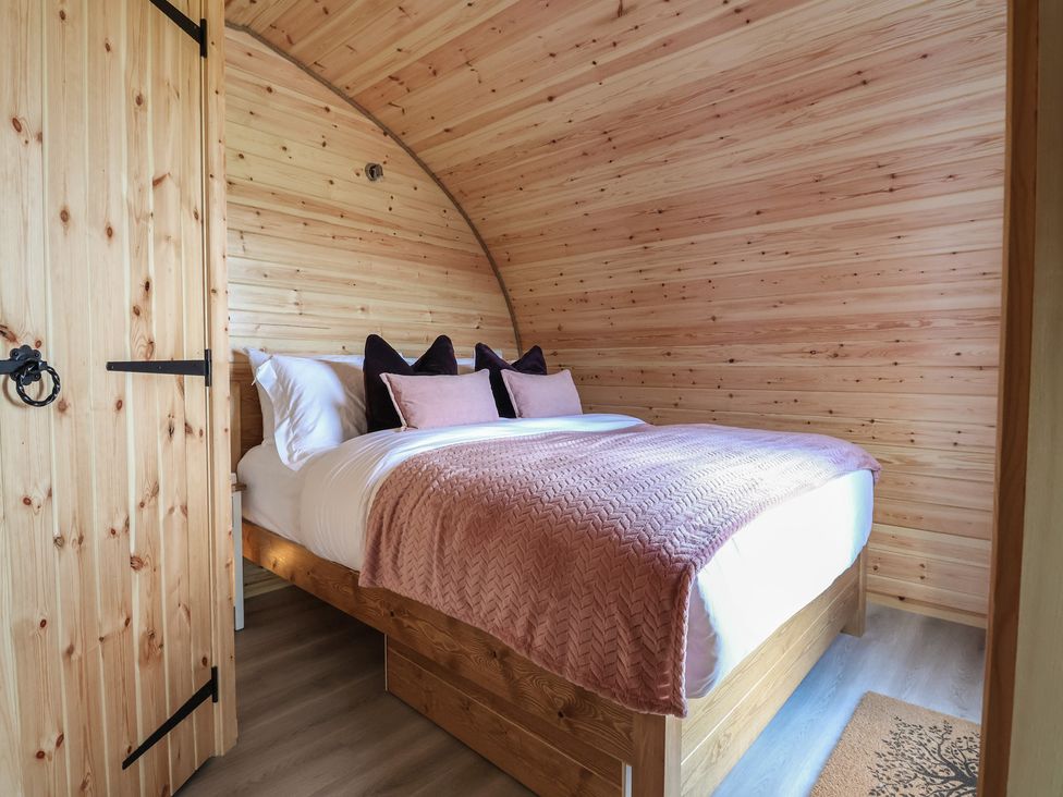 A bedroom with a bed and pillows at Cennin Pedr in Ruthin