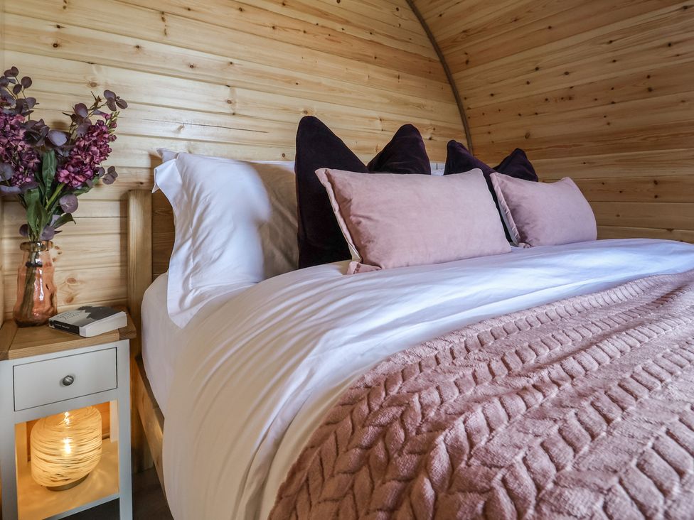 A bedroom with a bed and nightstand at Cennin Pedr in Ruthin
