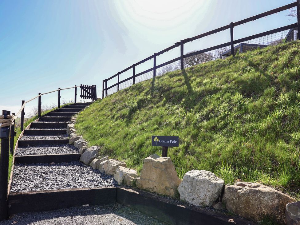 A pathway with stairs leading to a sign at Cennin Pedr in Ruthin
