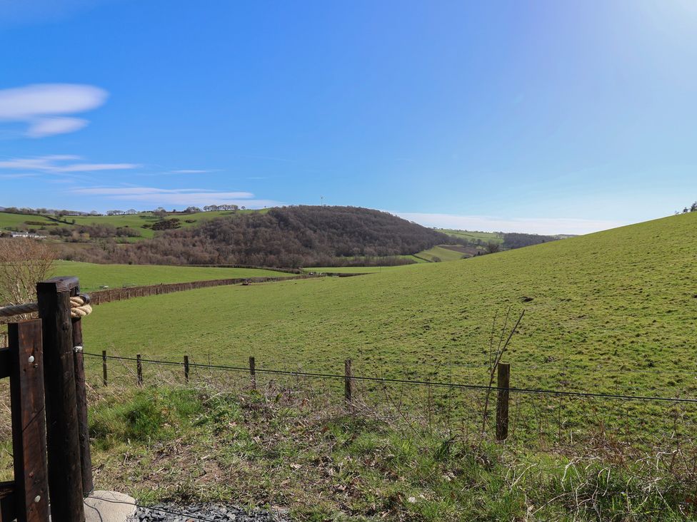 A view of rolling hills and grass fields at Cennin Pedr in Ruthin