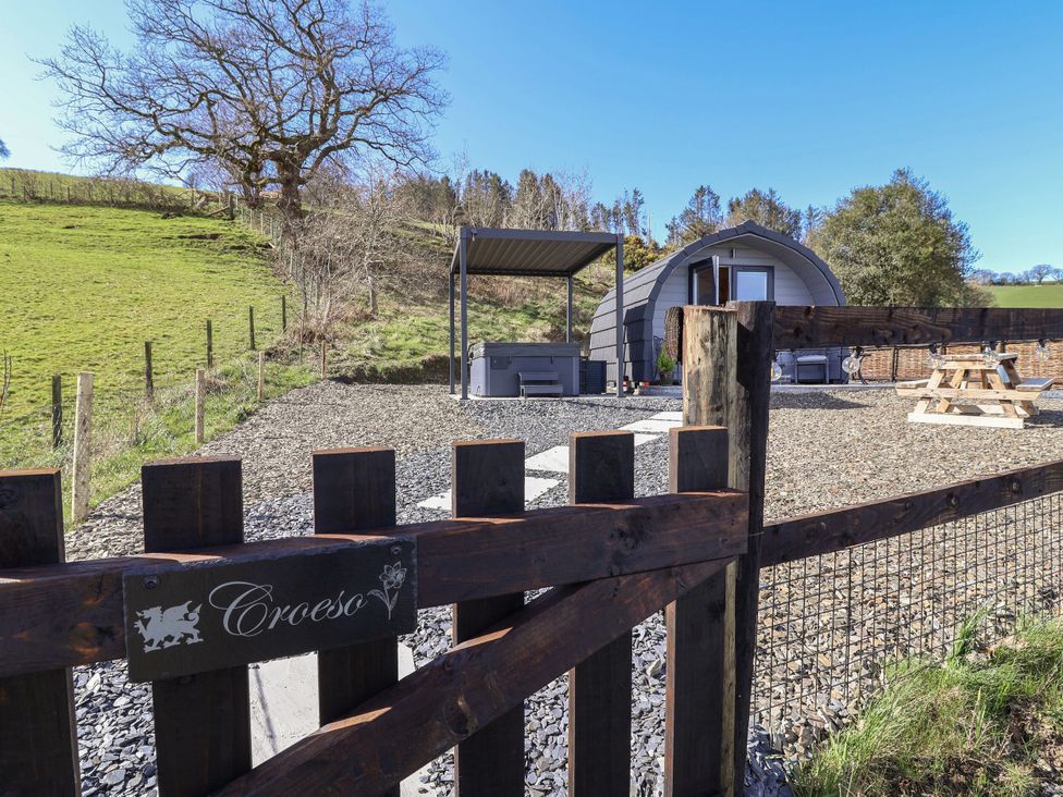 An outdoor area with a hot tub and picnic table at Cennin Pedr in Ruthin