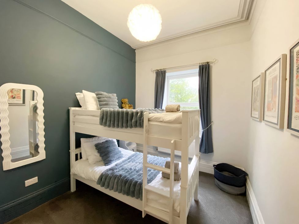 A bedroom with a bunk bed and a mirror at 2B Redcliffe in Torquay