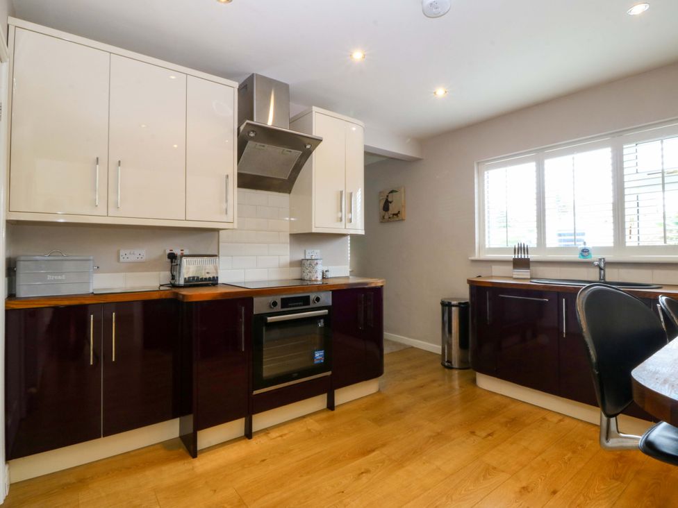 A kitchen with cabinets, an oven, and a sink at 5 Ger Afon Llanbedrog