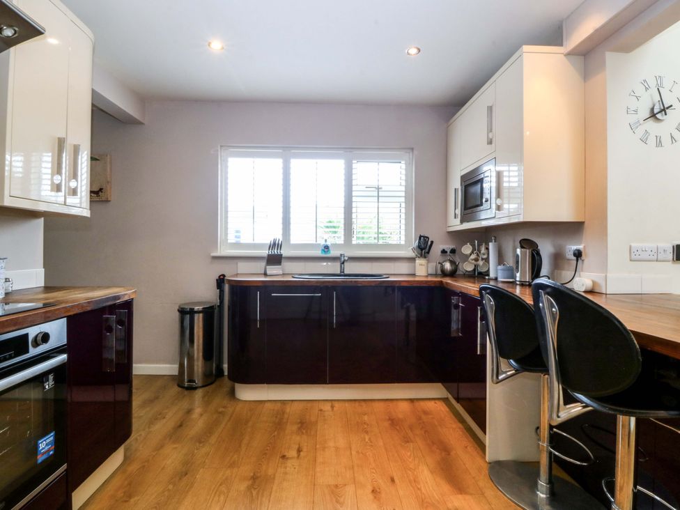 A kitchen with cabinets and a counter at 5 Ger Afon Llanbedrog
