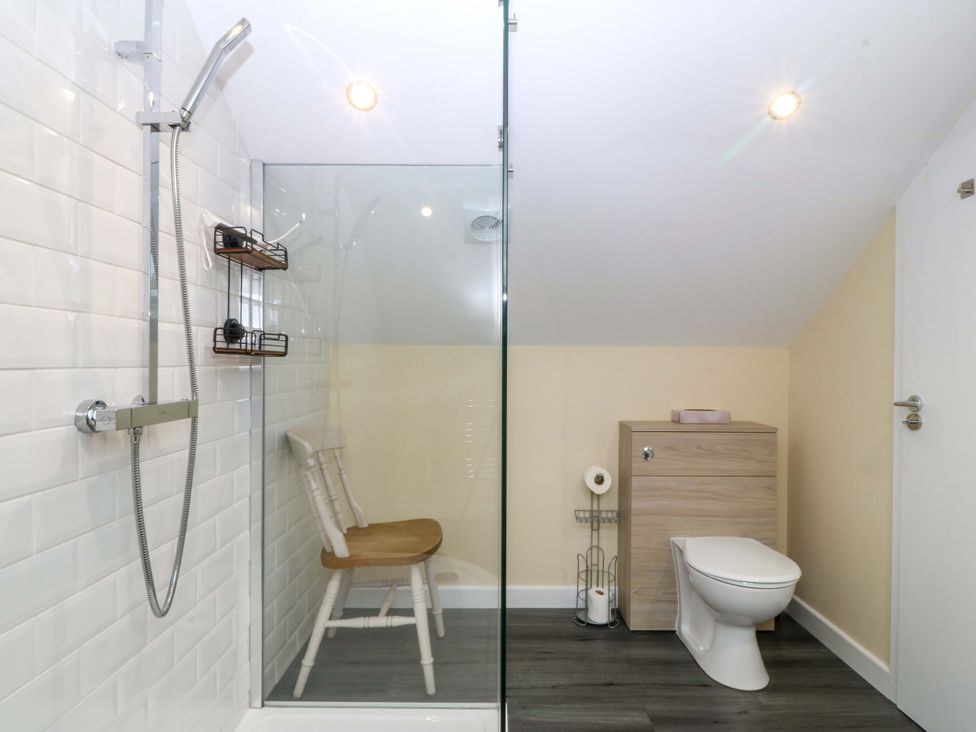 A bathroom with a shower, toilet, and vanity unit at 5 Ger Afon, Llanbedrog