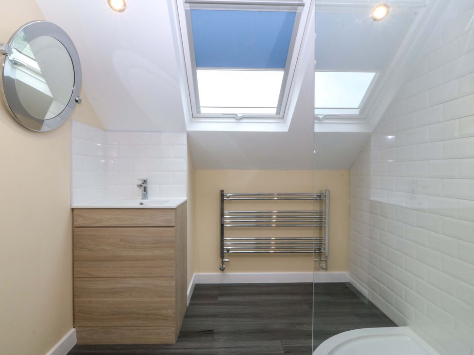 A bathroom with a sink and mirror at 5 Ger Afon in Llanbedrog
