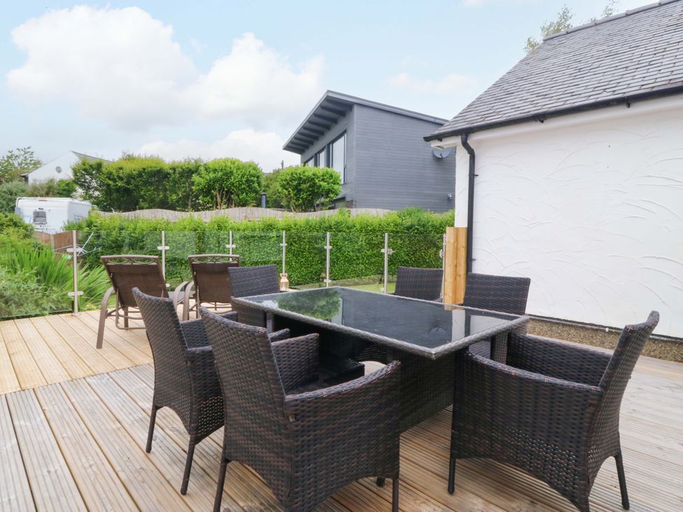 An outdoor dining area with a table and chairs at 5 Ger Afon Llanbedrog