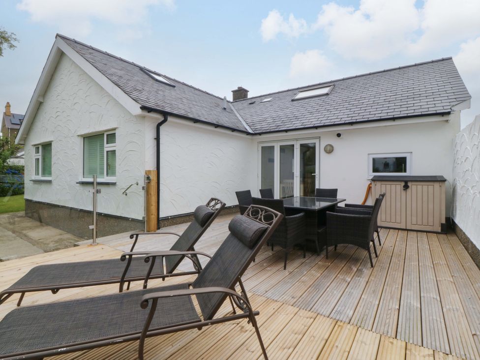 An outdoor patio with seating and a table at 5 Ger Afon, Llanbedrog