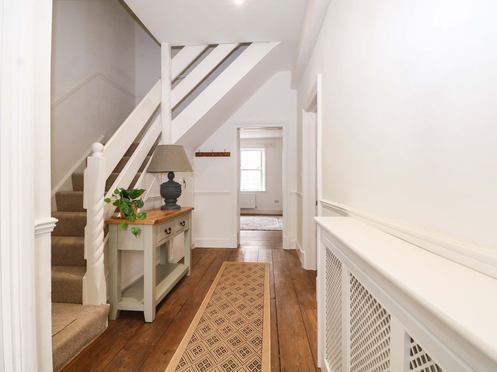 A hallway with a staircase and console table at 19 Queen Street Emsworth